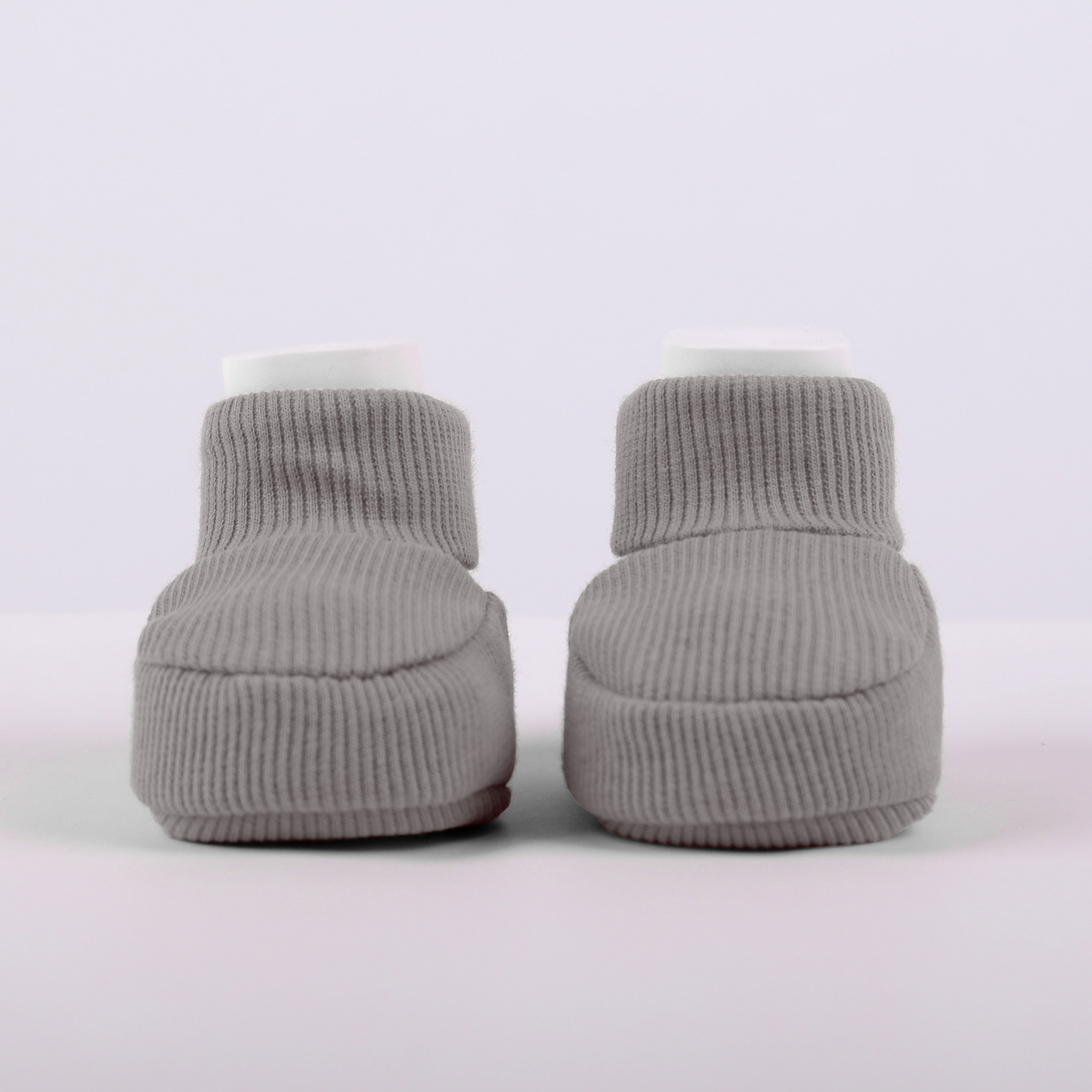 Organic cotton baby booties in gray, top view, on a light background