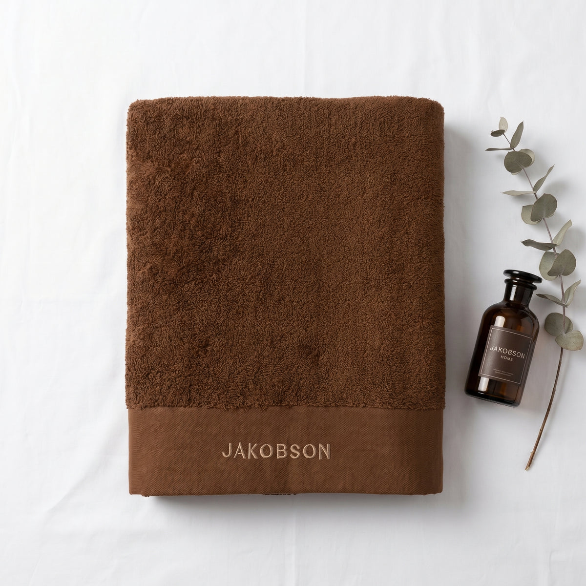 Organic cotton terry bath towel in cinnamon with Jakobson branding made from 100% organic cotton