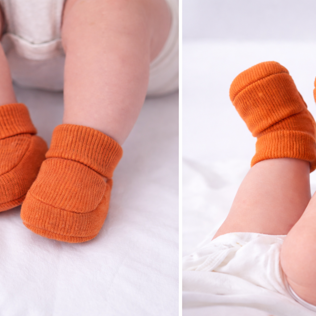 Child wearing organic cotton bronze baby booties on a white background
