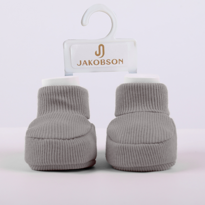 Organic cotton baby booties in gray with Jakobson branding designed for newborn comfort