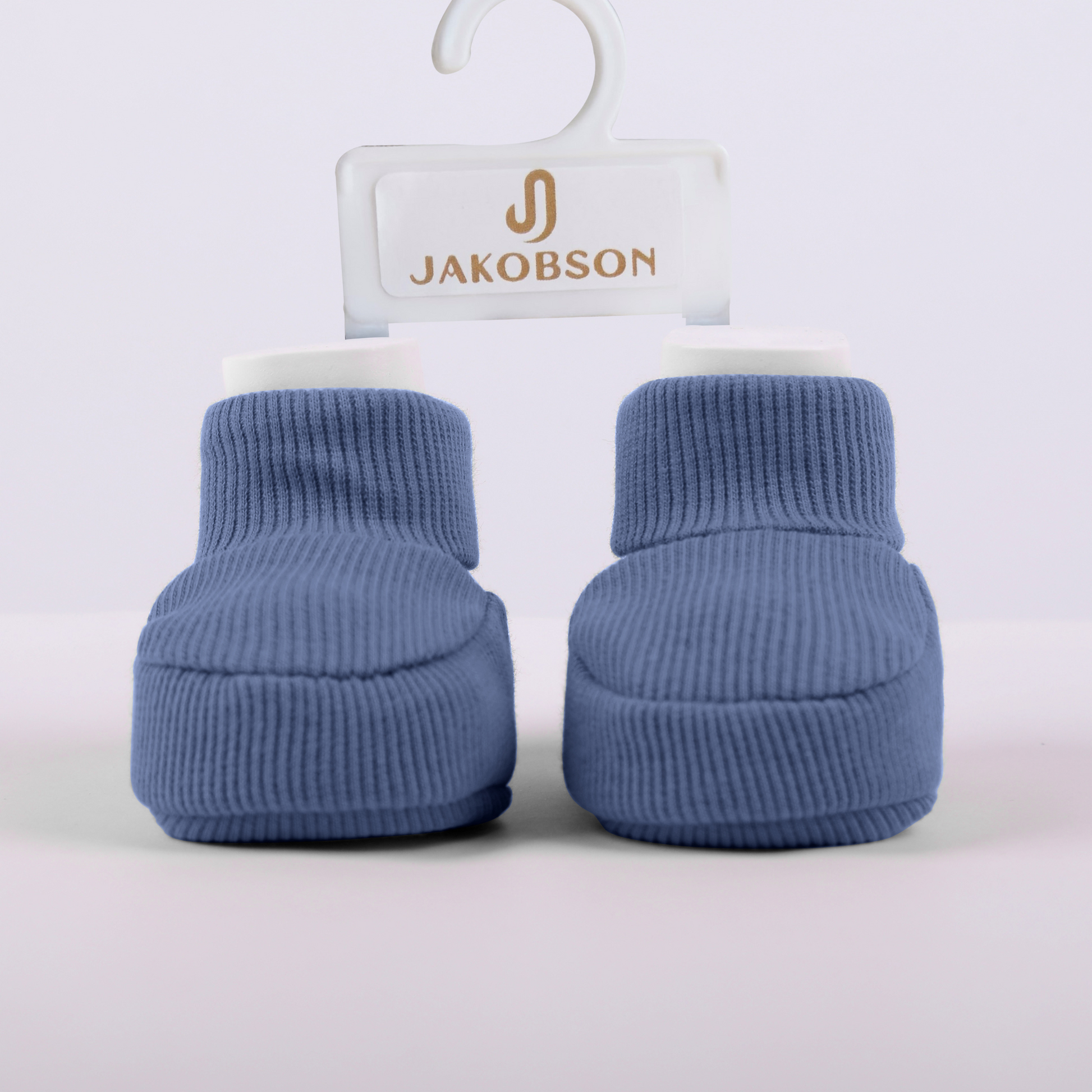Organic cotton baby booties in navy blue displayed on a Jakobson branded hanger for newborn comfort