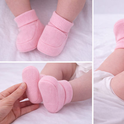 Baby wearing organic cotton pink baby booties designed for newborn comfort