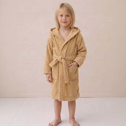 Child wearing a beige hooded robe on a plain background