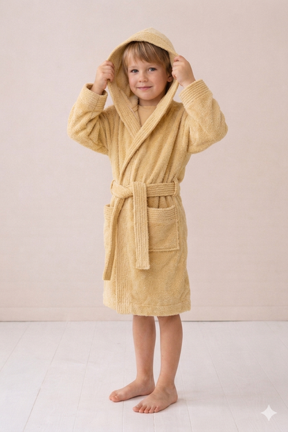 Child wearing a beige robe on a plain background