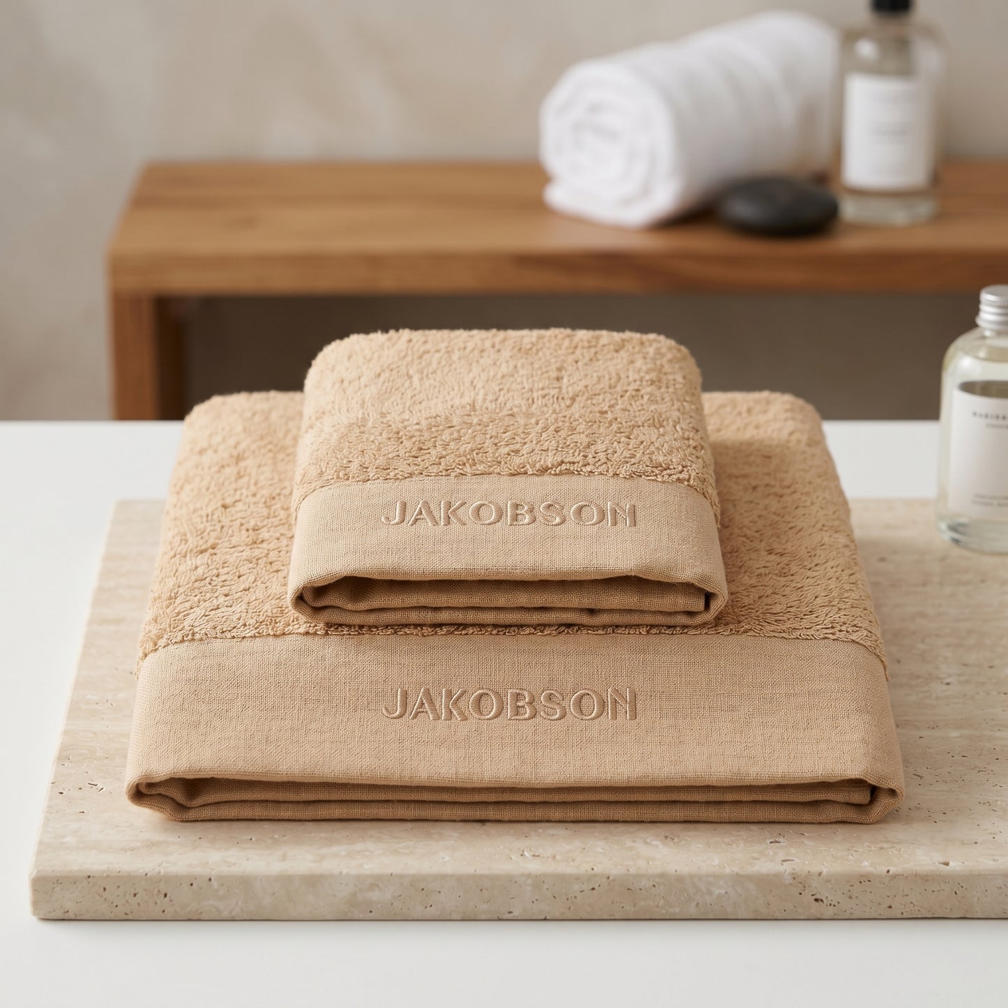 2-piece organic cotton towel set in beige with Jakobson branding made from soft terry fabric