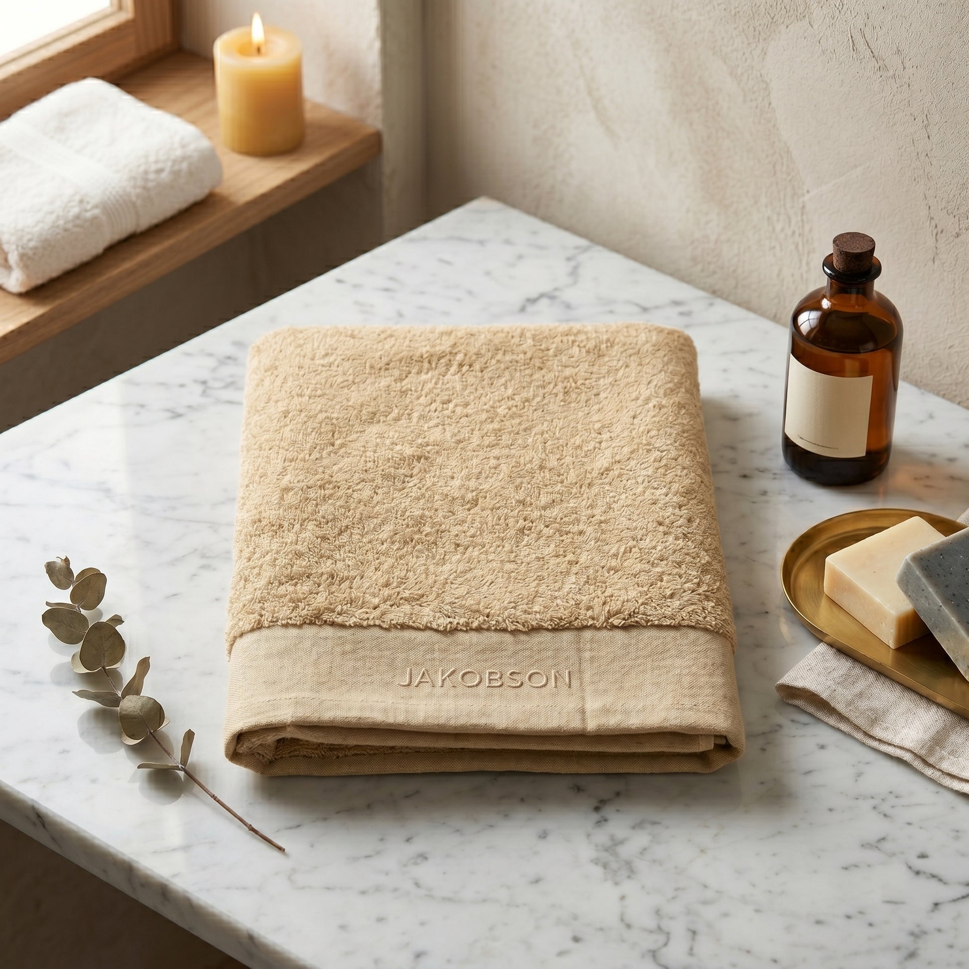Organic cotton terry bath towel in beige with Jakobson branding made from 100% organic cotton