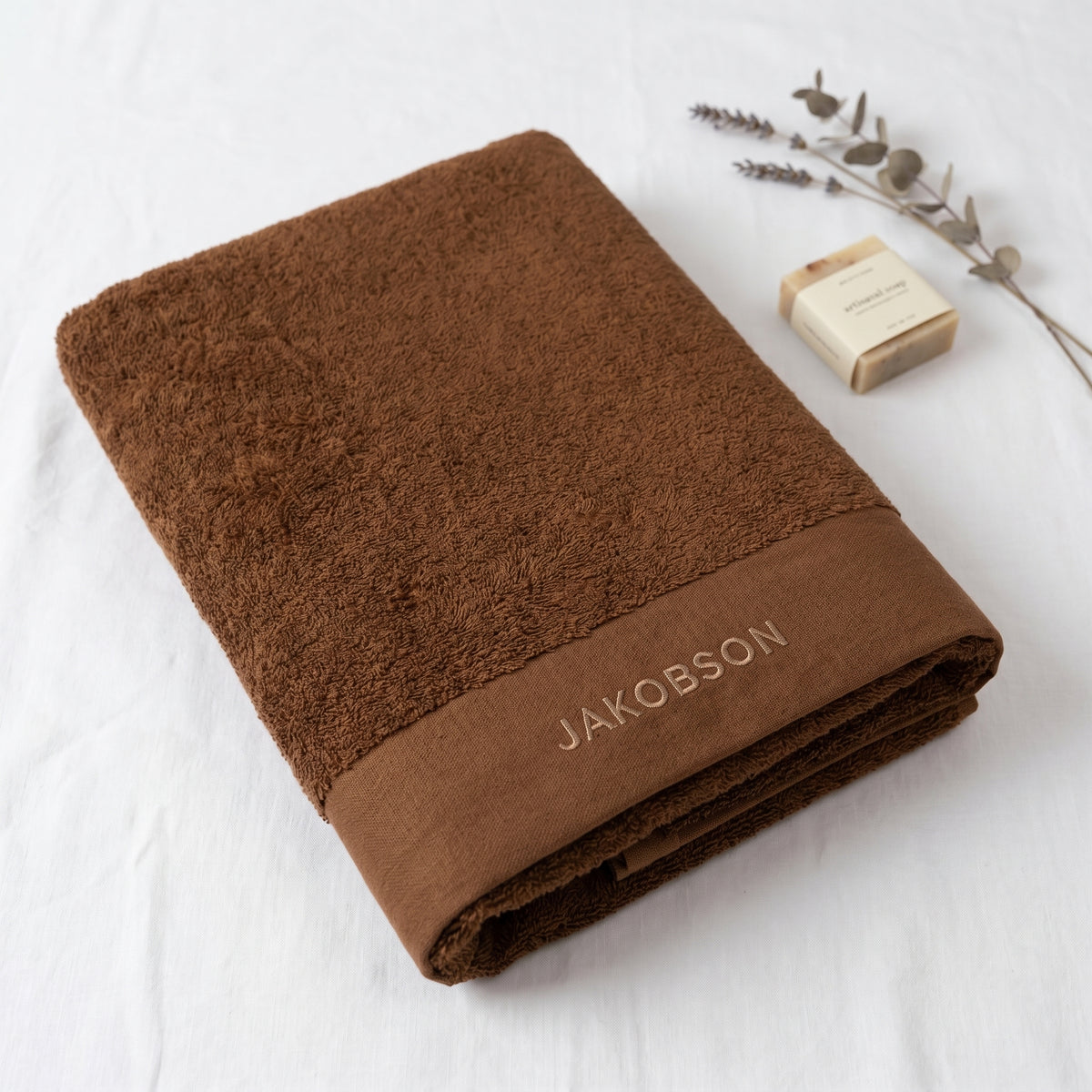 Organic cotton terry bath towel in cinnamon with Jakobson branding made from 100% organic cotton