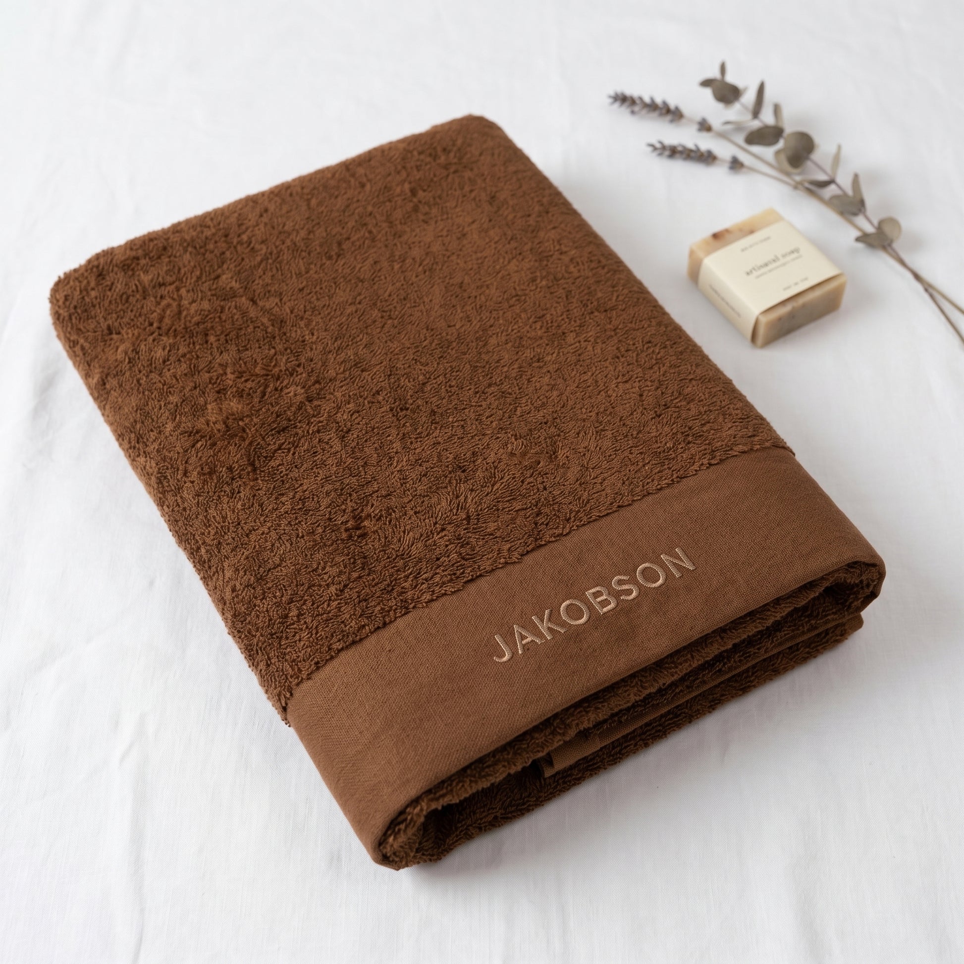 Organic cotton terry bath towel in cinnamon with Jakobson branding made from 100% organic cotton