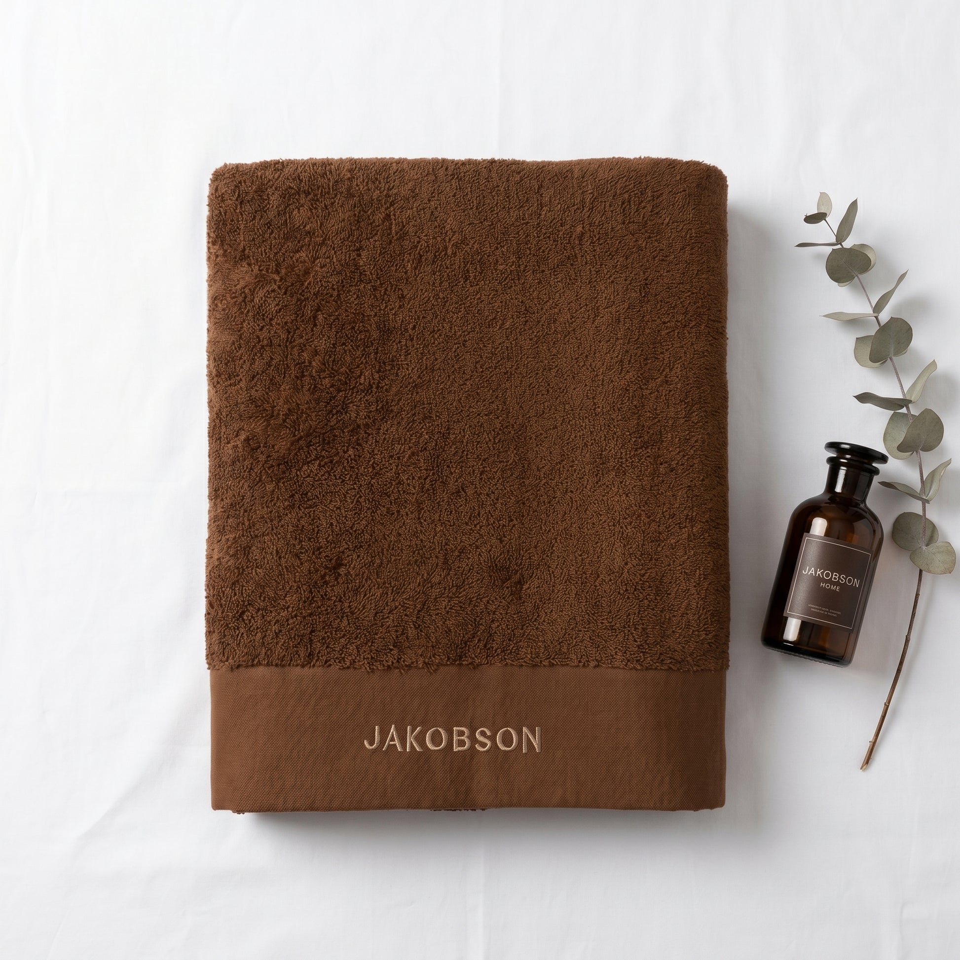 Organic cotton terry bath towel in cinnamon with Jakobson branding made from 100% organic cotton